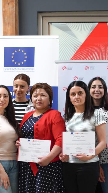 People standing with diplomas 